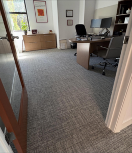 A modern office room with newly installed grey patterned carpet, a service provided by Rugs R Us Corporation in Fort Lauderdale, FL.