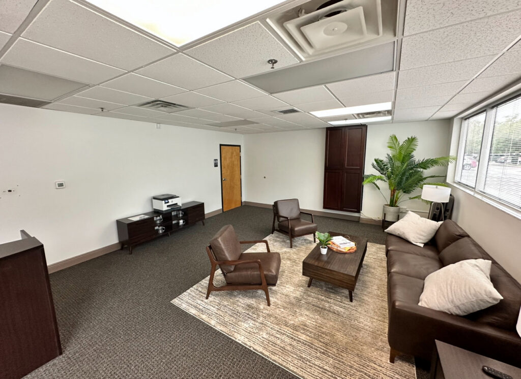 An office waiting area featuring a fresh dark grey carpet installation by Floored Solutions and Services, LLC in Orlando, FL.