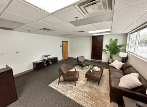 An office waiting area featuring a fresh dark grey carpet installation by Floored Solutions and Services, LLC in Orlando, FL.