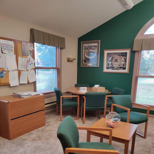 A carpeted office waiting area with green chairs, installed by Pape's Flooring America in Pittsburgh, PA