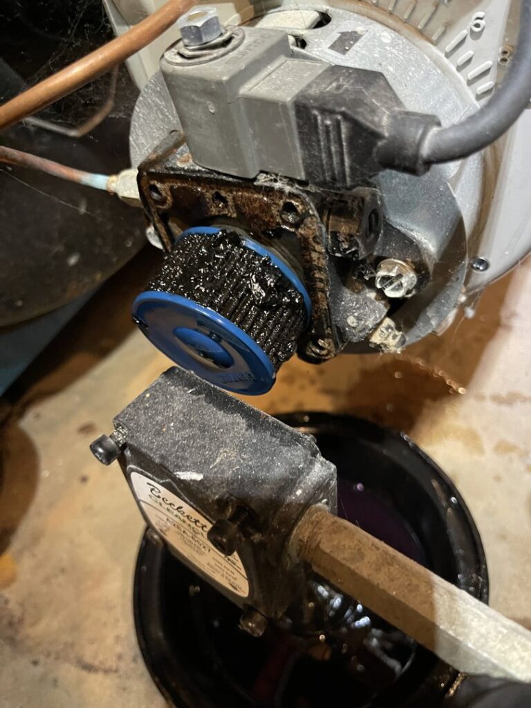 A close-up of a dirty oil burner filter being cleaned or replaced by MAC Heating and Cooling LLC in Waterbury, CT.