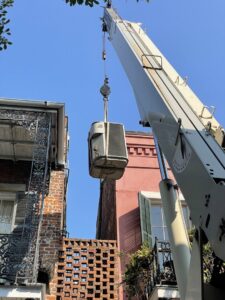 An old AC unit being removed by a crane for Caballero's A/C & Heating in Marrero, LA.