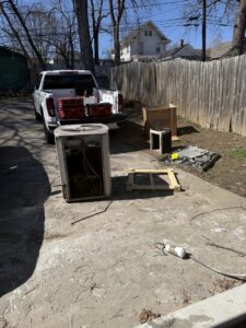 An old outdoor AC unit being removed or replaced by Affordable Heating & Cooling LLC in Olathe, KS.