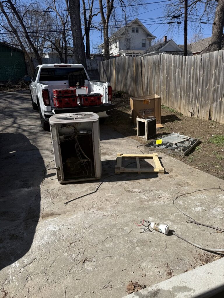 An old outdoor AC unit being removed or replaced by Affordable Heating & Cooling LLC in Olathe, KS.