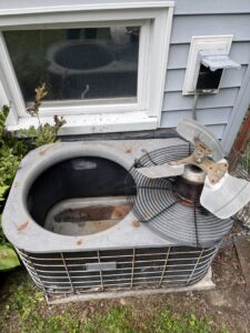 An old outdoor AC unit with its fan removed, indicating repair or replacement work by L&SON Heat AC Tech in Yonkers, NY.