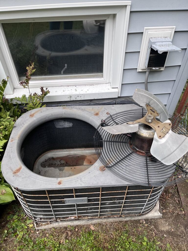 An old outdoor AC unit with its fan removed, indicating repair or replacement work by L&SON Heat AC Tech in Yonkers, NY.