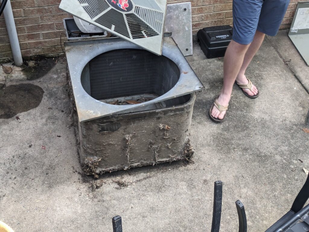 An old, dirty outdoor AC unit being replaced by Honesty Services in Rock Hill, SC.