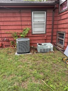 An old AC unit next to a new one, indicating a replacement job by G.M. AIR Conditioning & Heating in Wichita, KS.