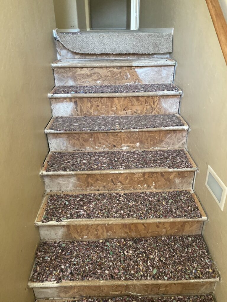 Old carpet and padding being removed from stairs by Mark Hart Flooring Consultant at RM Interiors & Design in Mesa, AZ.