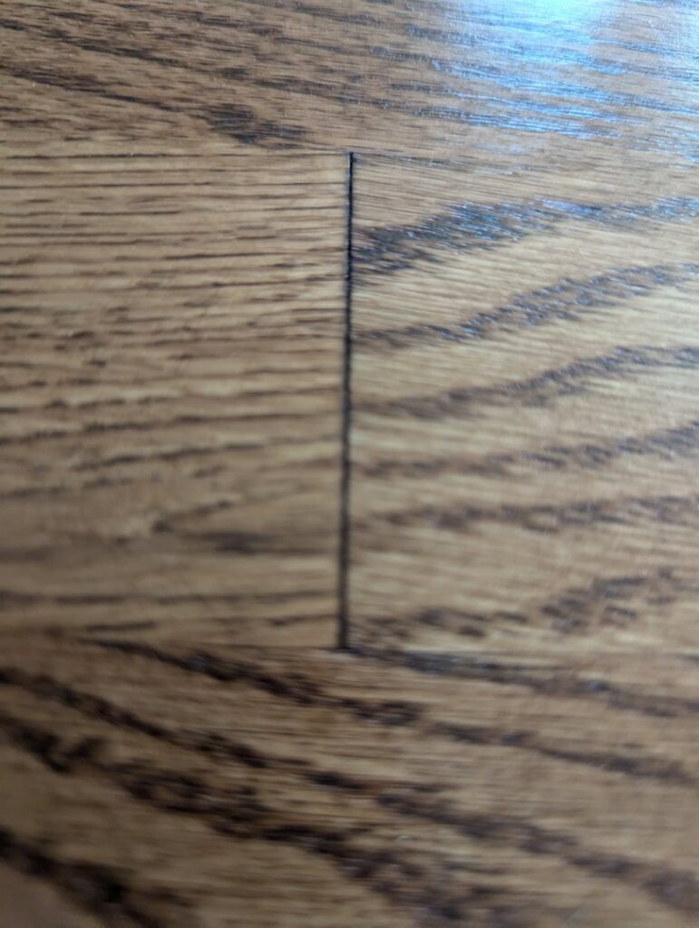 Old carpet being removed, revealing a damaged subfloor, a service provided by Junge's Flooring in Rochester, MN