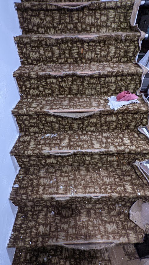 Old carpet removal from a staircase, a carpet contractor job in progress by National Carpet and Flooring in Tyngsboro, MA.