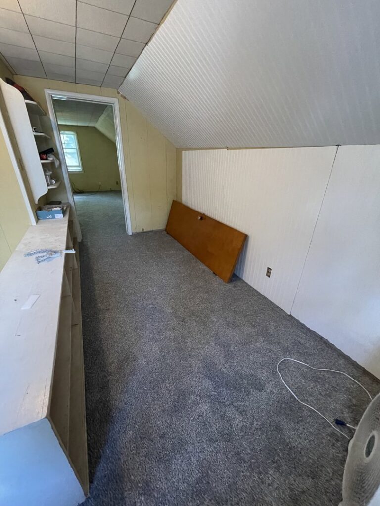 A room with old gray carpet, likely before renovation by Flooring World Wide LLC in Plainwell, MI.
