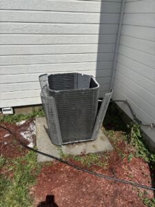 An old or damaged outdoor AC condenser unit, ready for replacement by Kingdom Heating and Air in Sacramento, CA.