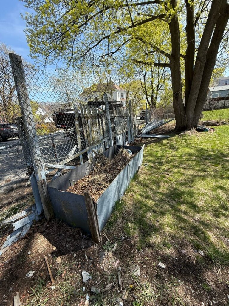 An old and dilapidated chain-link fence in a yard, showing potential work for Matul Fence Inc in Lynn, MA