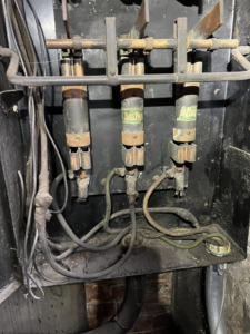 An interior view of an old electrical fuse box with Buss Fuses and wiring, showing a typical job for KNK Electric in Pittsburgh, PA.