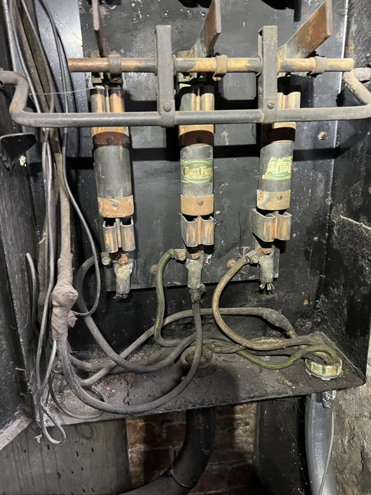 An interior view of an old electrical fuse box with Buss Fuses and wiring, showing a typical job for KNK Electric in Pittsburgh, PA.