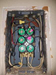An old electrical fuse box with multiple fuses and wiring, inspected by My A Plus Electric SA in San Antonio, TX