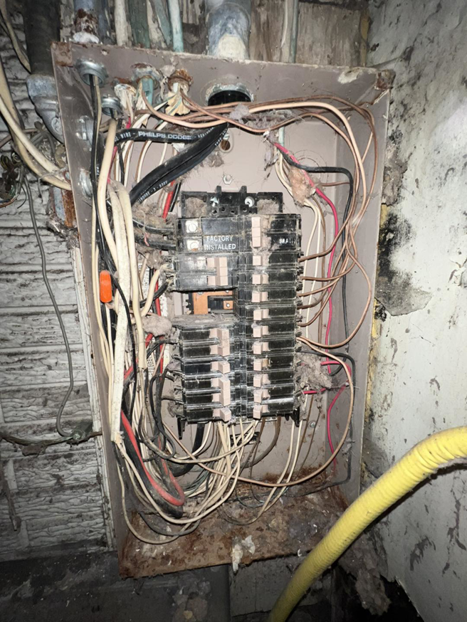 An old, messy electrical panel with tangled wires, indicating a need for an upgrade by F&C Electrical Services LLC in Iowa City, IA.