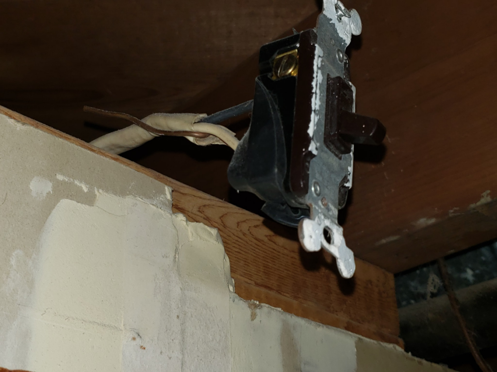 Close-up of an old electrical light switch with exposed wiring, showing work by BMB ELECTRIC LLC in Columbus, OH.