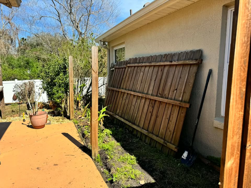 Old fence panels removed and new posts installed for a replacement project by Native Outdoors, LLC in Orlando, FL.