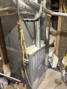 An old furnace and air handler unit with ductwork, ready for service or replacement by Affordable Heating & Cooling LLC in Olathe, KS.