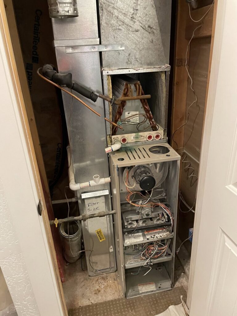 An old furnace unit disassembled for repair or replacement by ICare Heating & Air in Millcreek, UT.