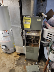 An old, dirty furnace awaiting inspection or replacement by Orchard Heating-Cooling and Sheet Metal in Stow, OH.