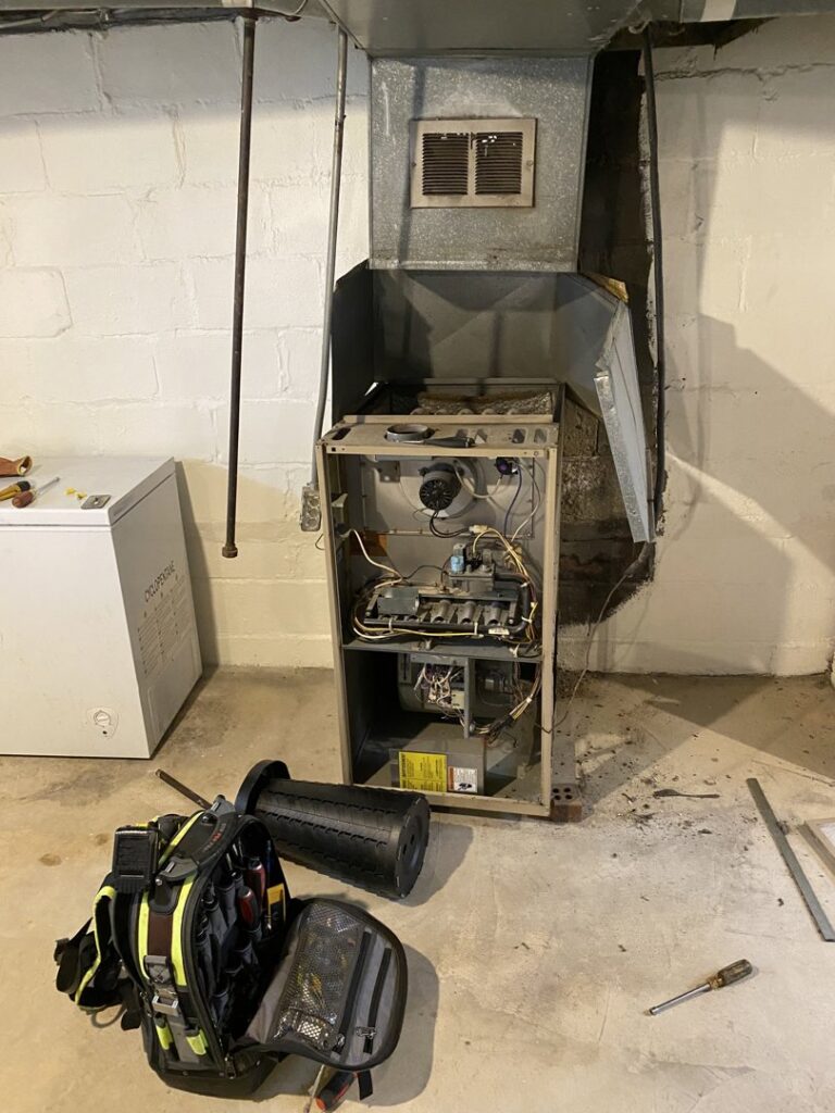 An old furnace with its front panel removed for repair or service by All Around Heating & Cooling in Akron, OH.