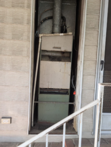 An old, worn-out furnace unit before replacement by Rosales Aire Inc., an HVAC contractor in Anaheim, CA.