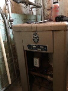 An old H&M Gas Boiler unit, likely being serviced or inspected by West Tennessee Heat & Air in Memphis, TN