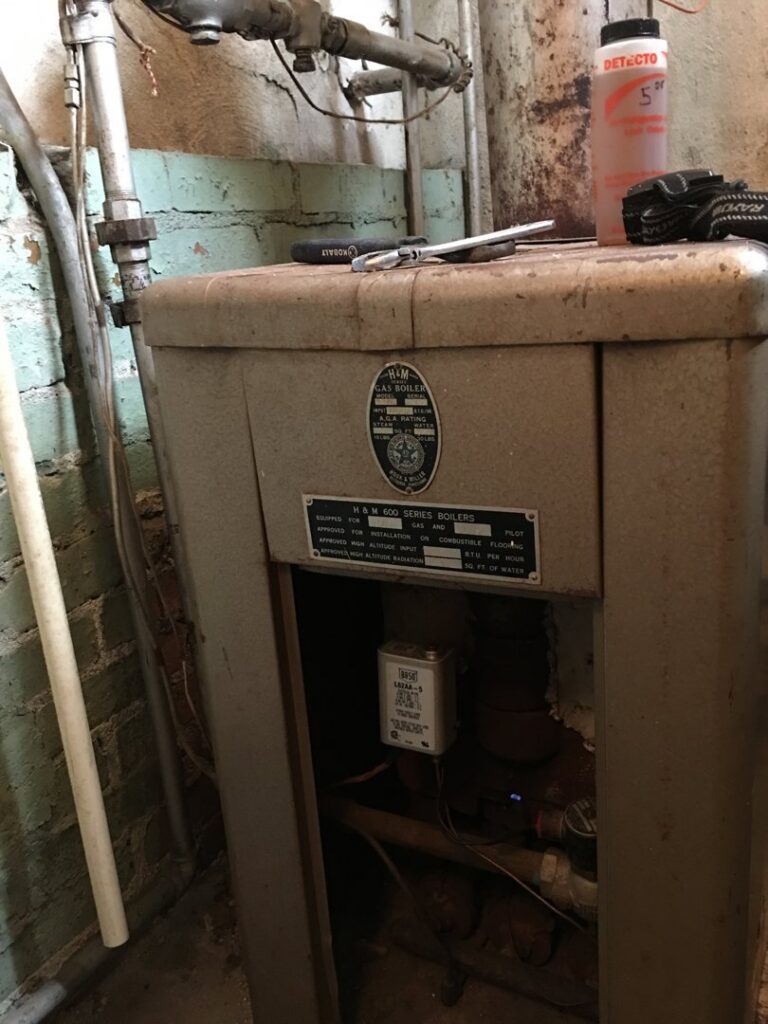 An old H&M Gas Boiler unit, likely being serviced or inspected by West Tennessee Heat & Air in Memphis, TN