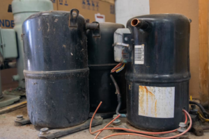 Old HVAC compressors, likely awaiting replacement or disposal by AirTemp Heating & Cooling in Nashville, TN.