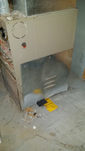 An old HVAC furnace unit, possibly undergoing repair or replacement by Proficient Heating & Cooling in Livonia, MI.