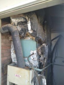 An old HVAC furnace system with insulated ductwork and piping, ready for inspection by ReDesign Air in Winchester, VA.