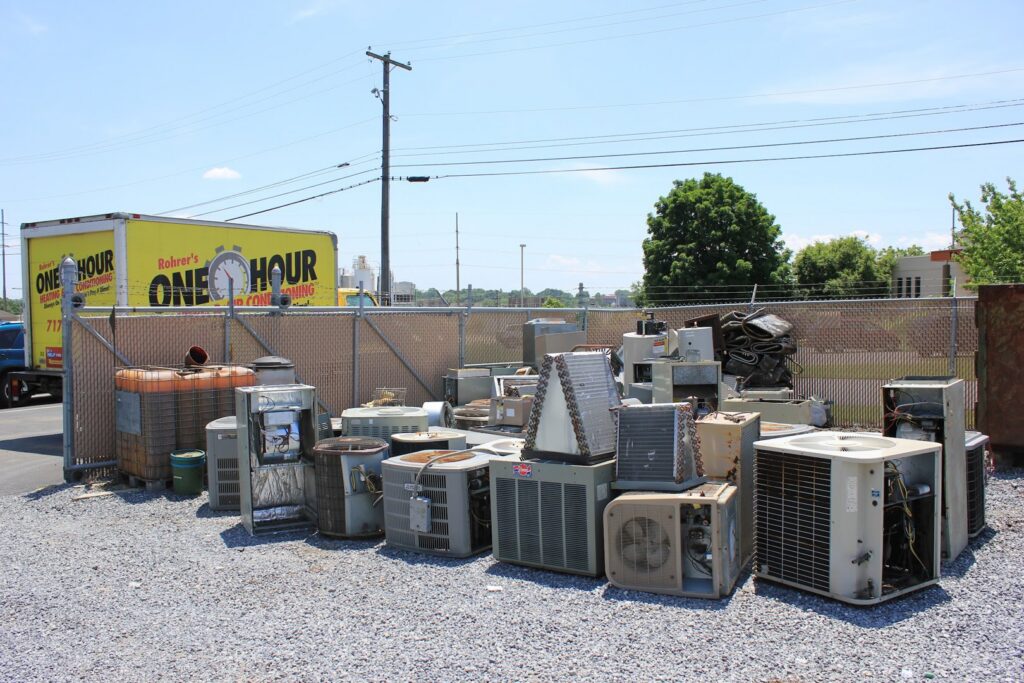 A pile of old HVAC units and scrap metal ready for disposal by One Hour Heating & Air Conditioning of Lancaster, PA.