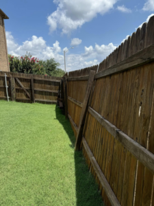 An old, leaning wooden fence in need of repair, showcasing potential work for T&G Outdoor Services in Austin, TX.