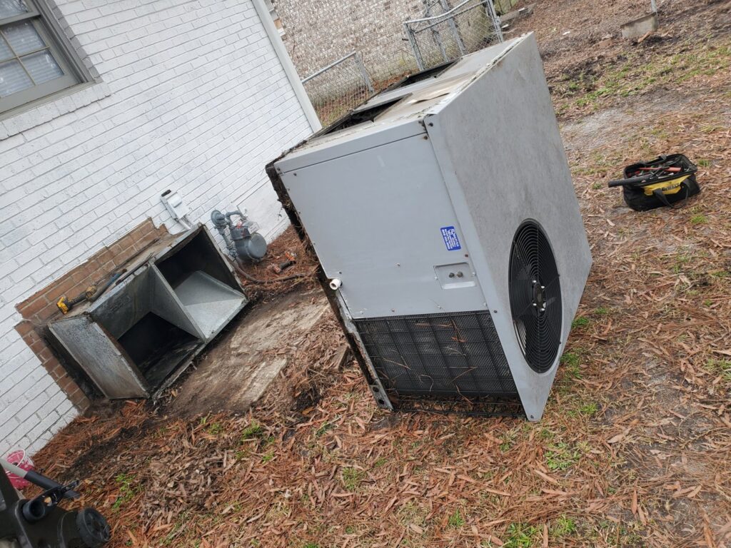 An old outdoor AC unit being removed for replacement by Honesty Services in Rock Hill, SC.