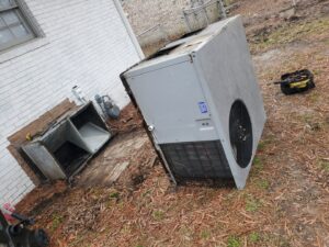 An old outdoor AC unit being removed for replacement by Honesty Services in Rock Hill, SC.