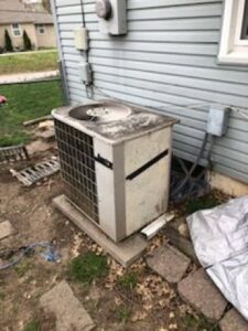 An older outdoor air conditioner unit, ready for service or replacement by Bellis Heating & Cooling in Independence, MO.