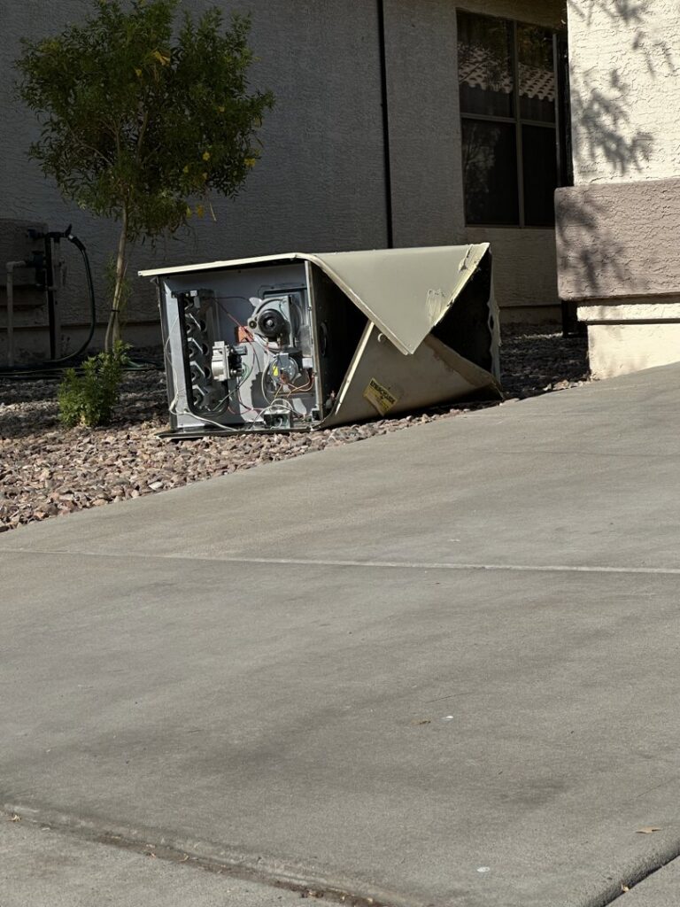 An old, damaged rooftop AC unit being removed by a crane during a replacement job by ASAP Air Conditioning and Heating in Mesa, AZ.
