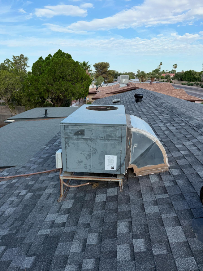 An old rooftop HVAC unit on a shingle roof, ready for inspection or replacement by Otto's Air Conditioning & Heating in Mesa, AZ.