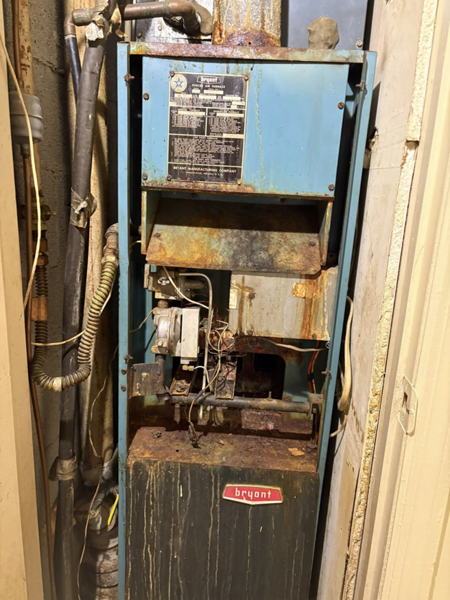 An old, rusty Bryant furnace unit with exposed components, indicating a need for service from Pepper Mechanical in Pittsburgh, PA