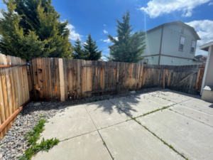An old, weathered wooden fence in a backyard, showing conditions before replacement by Mule Fence Inc. in Sparks, NV.
