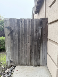 An old, weathered wooden pedestrian gate, showing a potential project for Exclusive Custom Iron Works in Stockton, CA.