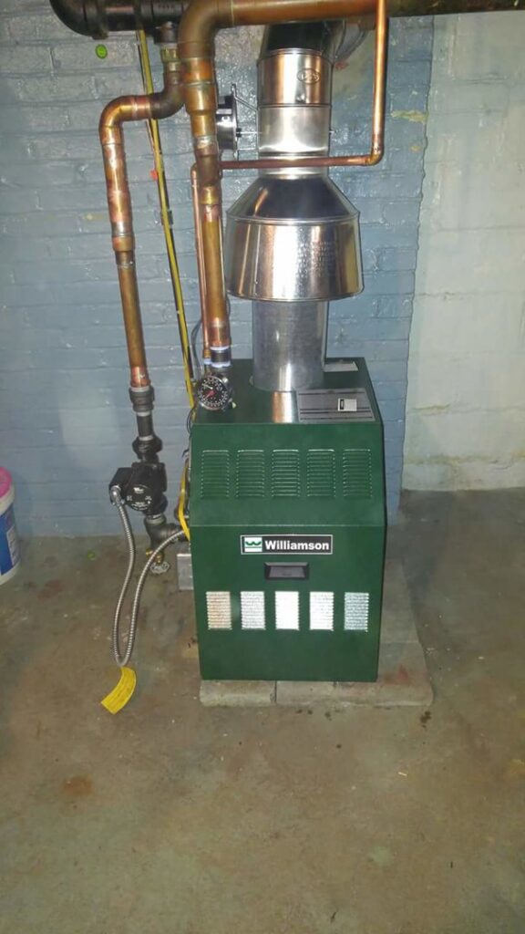 An older green Williamson boiler heating system with copper piping, serviced by R. Davis Mechanical in Pittsburgh, PA