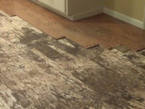 Old wood flooring being removed to reveal a concrete base, a service by Clean Site Flooring Removal in Sacramento, CA.