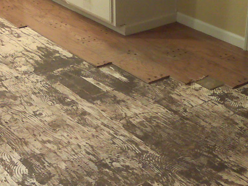 Old wood flooring being removed to reveal a concrete base, a service by Clean Site Flooring Removal in Sacramento, CA.