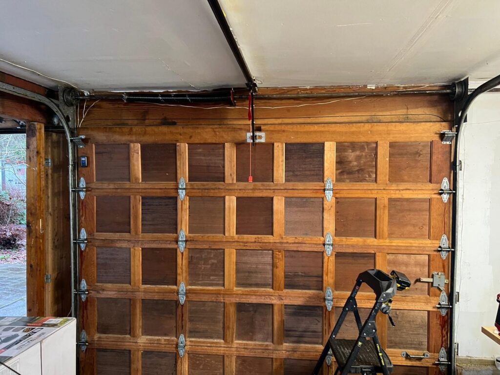Interior view of an old wooden garage door, showing its panels and tracks, by AAA Garage Door Services in Renton, WA