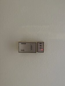 An older analog thermostat on a wall, serviced by Tadlock Heating & Air Conditioning in Tallahassee, FL