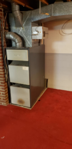 An older furnace and HVAC system in a basement by Neumeyer Mechanical Service in Pittsburgh, PA